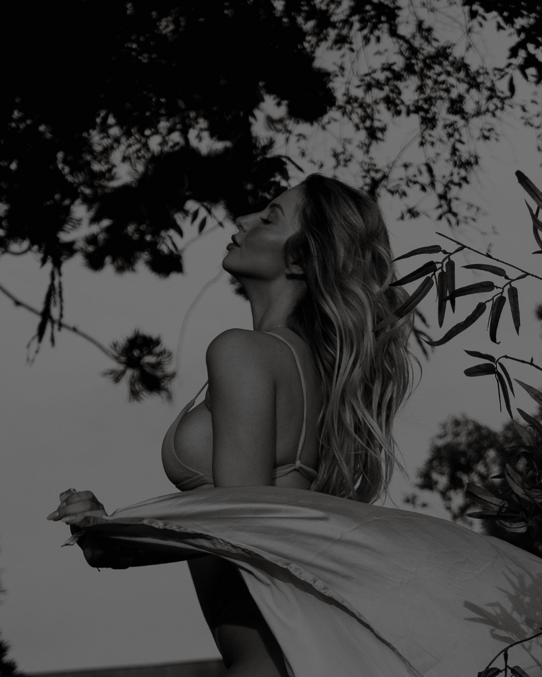 A woman in a flowing dress beneath the trees